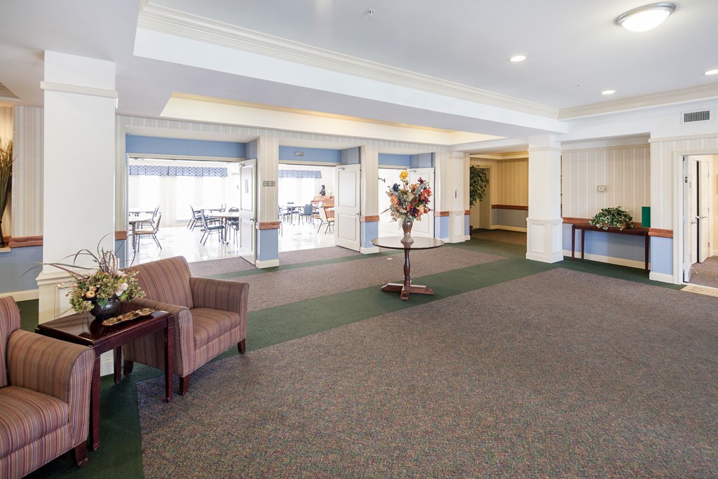 a lobby with couches and chairs and a table with flowers