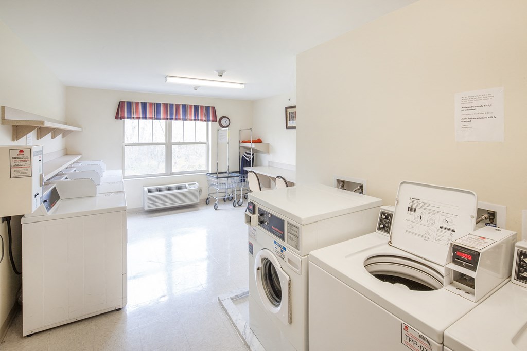 a laundry room with washer and dryers and a window