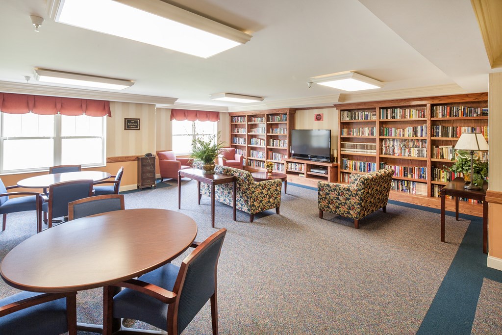 a library with tables chairs and chairs and a television