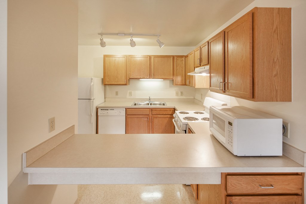 a kitchen with wooden cabinets and a microwave on the counter