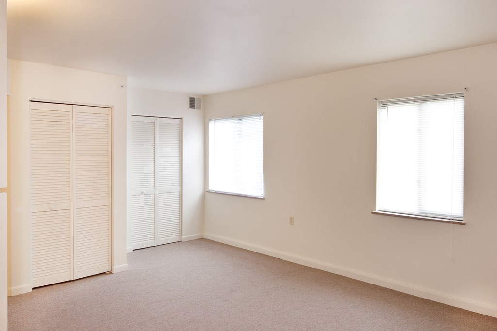 an empty living room with white walls and a door and window