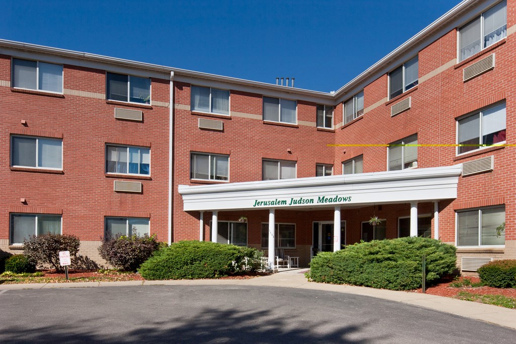 an exterior view of a brick building with a white entrance