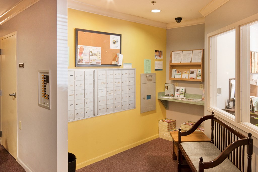 a counselling room with a bench and a bulletin board with a calendar on the wall