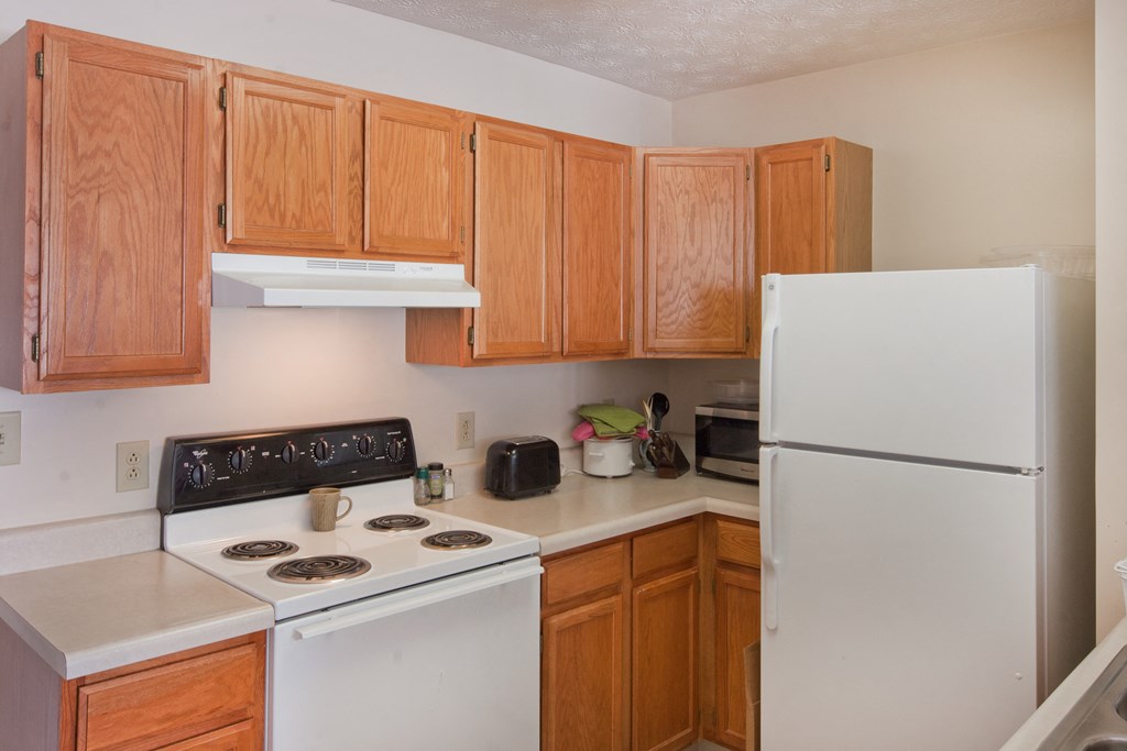a kitchen with white appliances and wooden cabinets