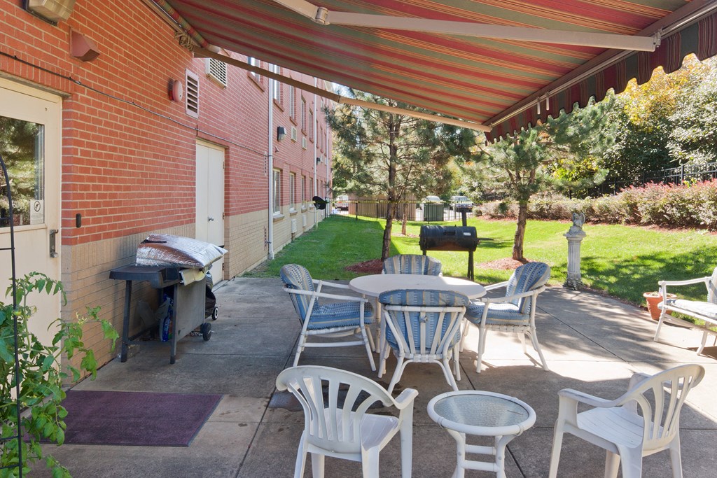 a patio with tables and chairs outside of a brick building