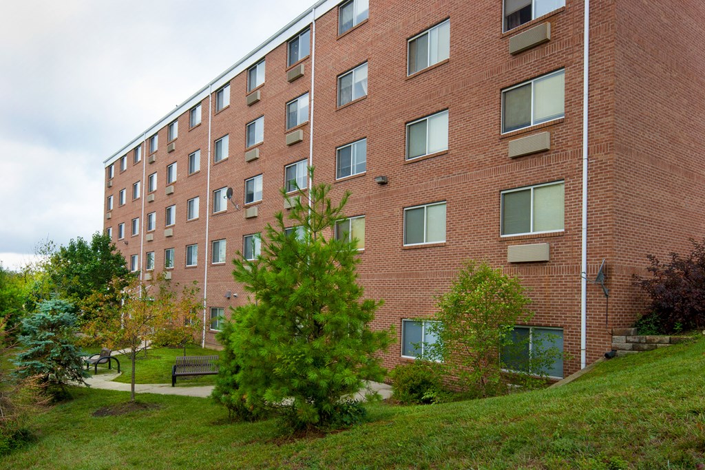 a brick building with trees and grass in front of it