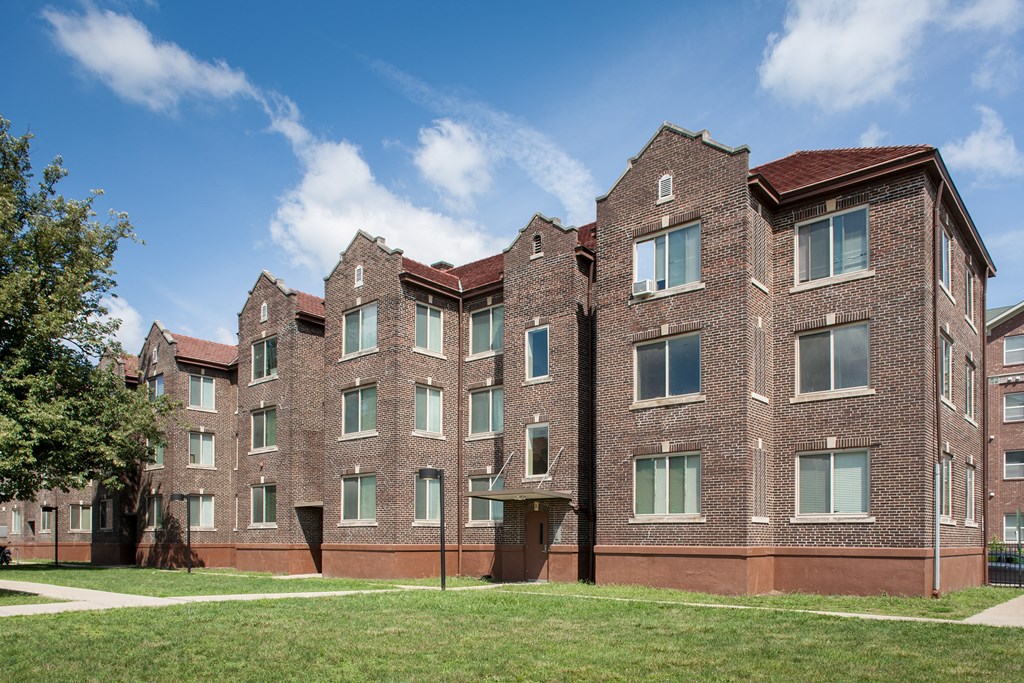 a large brick building with grass in front of it