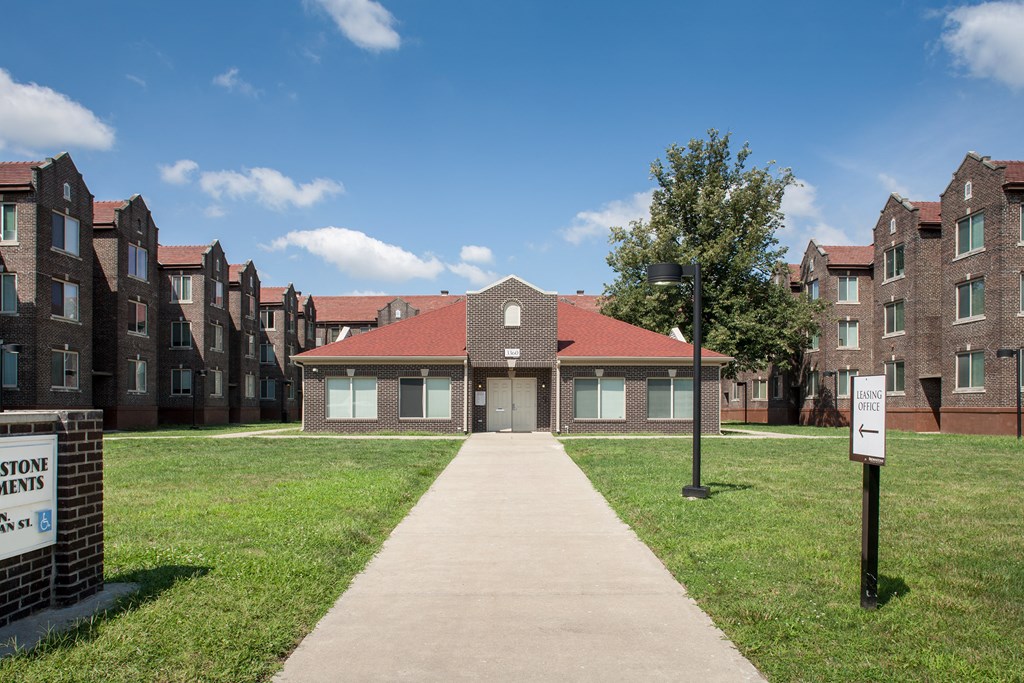a pathway leading to a building with a sidewalk and grass