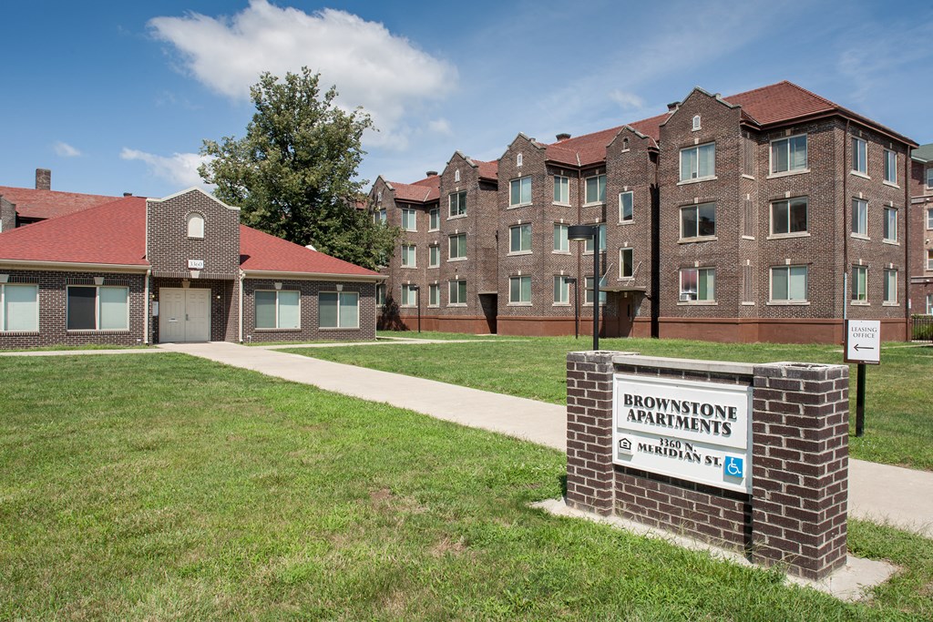 a brick apartment building with a sign in front of it