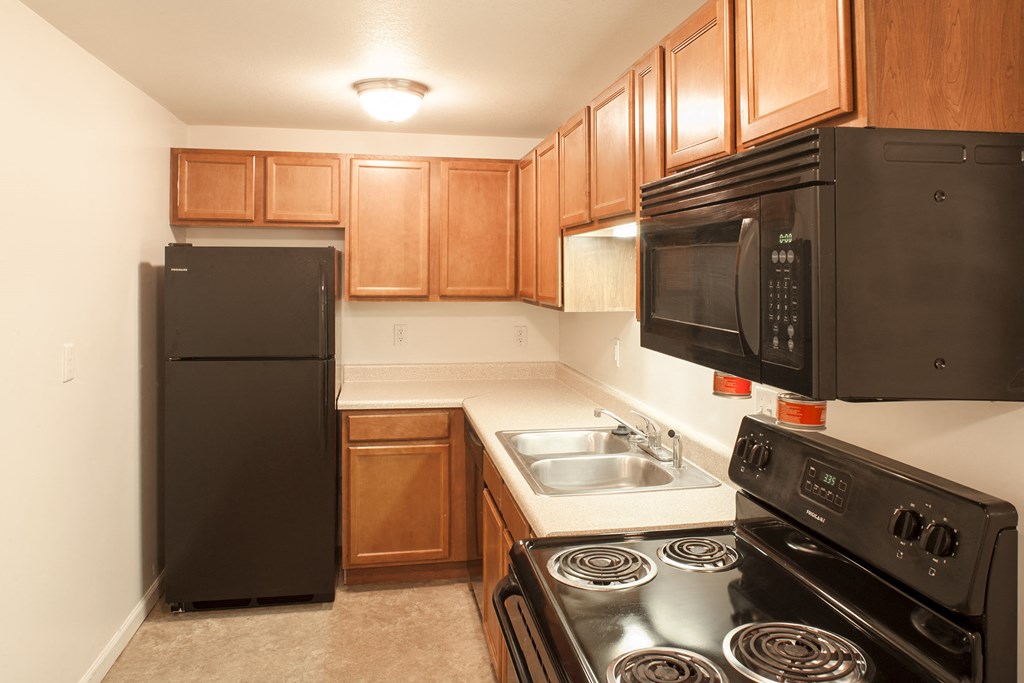 a kitchen with black appliances and wood cabinets