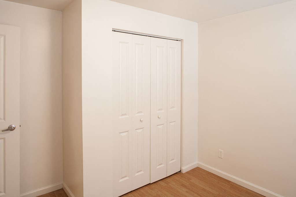 a bedroom with two closets and a wood floor