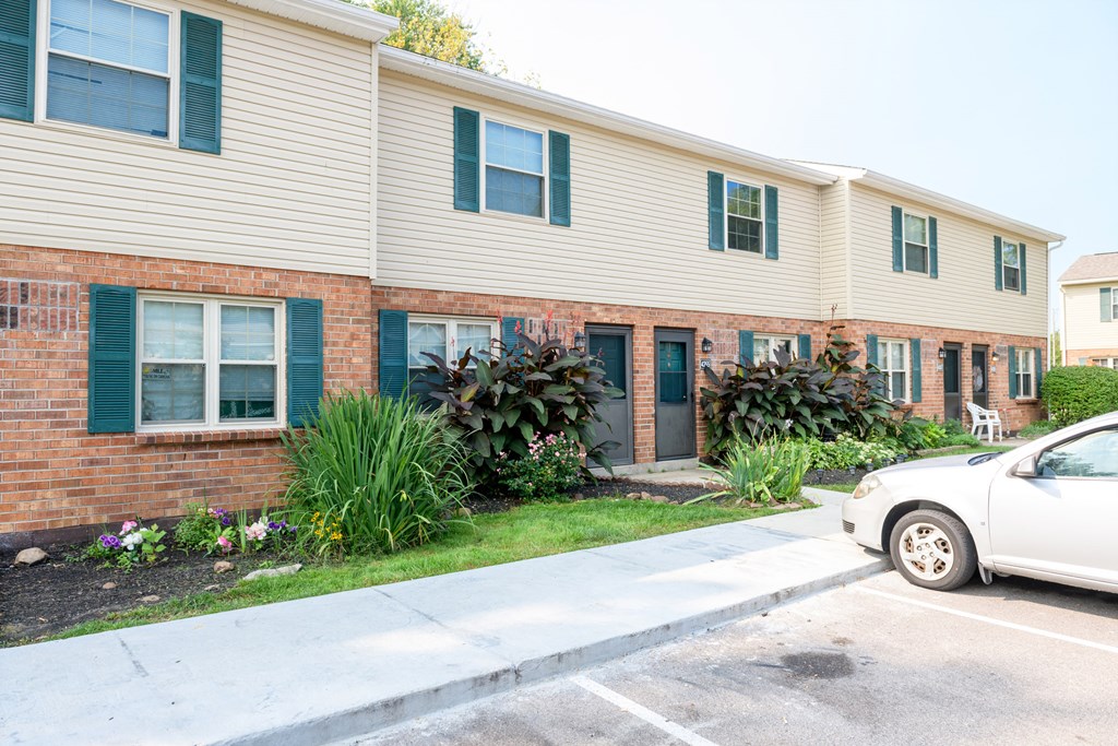 a white car parked in front of an apartment building