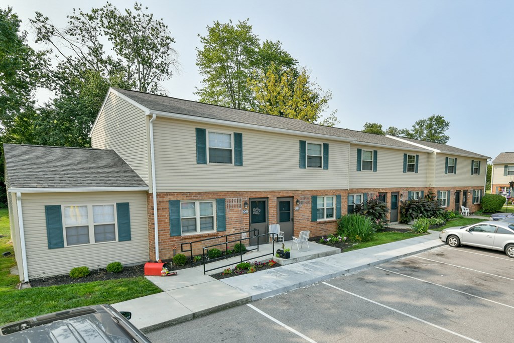 a white house with a driveway and a parking lot