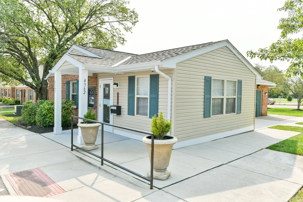 the front porch of a small house with a porch swing