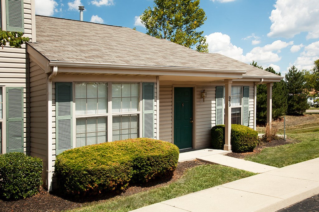 a small white house with a sidewalk in front of it