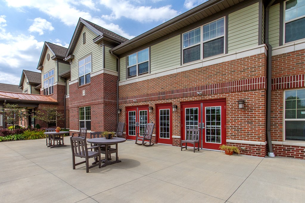a patio outside of a brick building with tables and chairs
