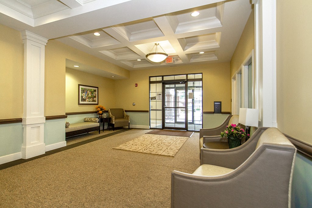 a lobby with couches and chairs and a glass door