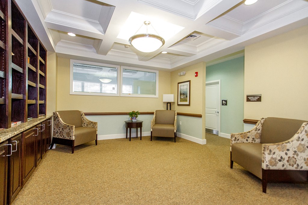 a waiting room with chairs and a table and a window