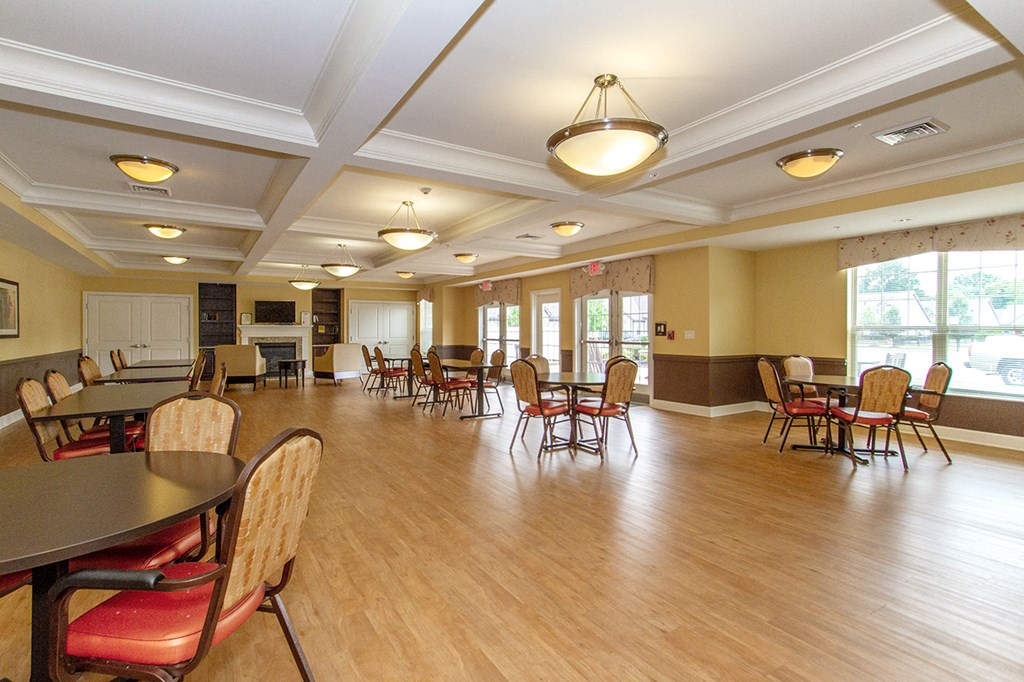 a large room with tables and chairs and a wood floor