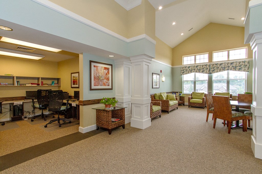 a lobby with a reception desk and a seating area with chairs and tables
