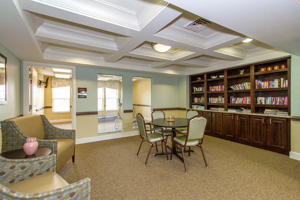a dining room with a table and chairs and a bookshelf