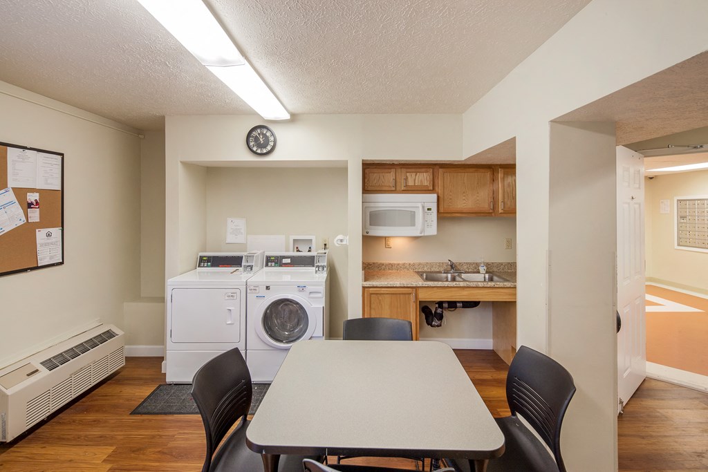 a kitchen and dining room with a table and chairs and a washer and dry