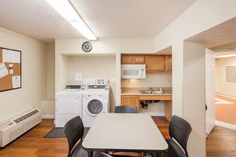 a kitchen and dining room with a table and chairs and a washing machine