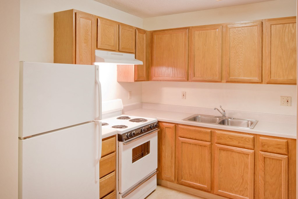 a kitchen with white appliances and wooden cabinets
