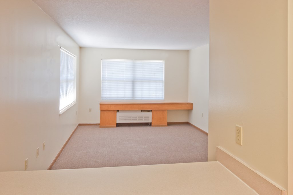 an empty room with a desk and a window