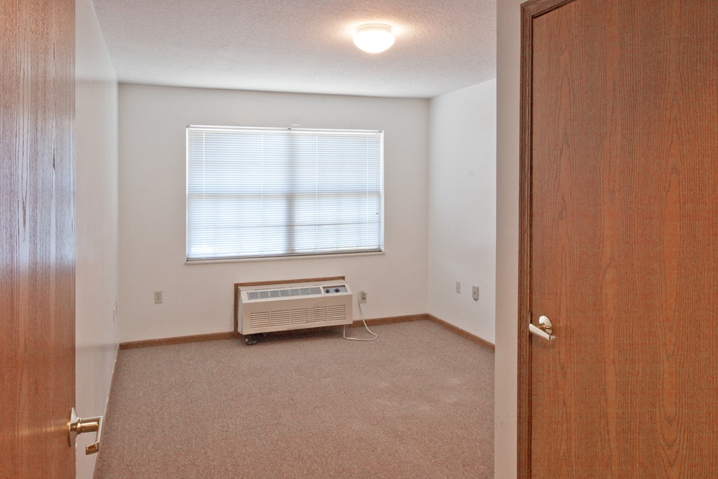 an empty room with an open door and a window