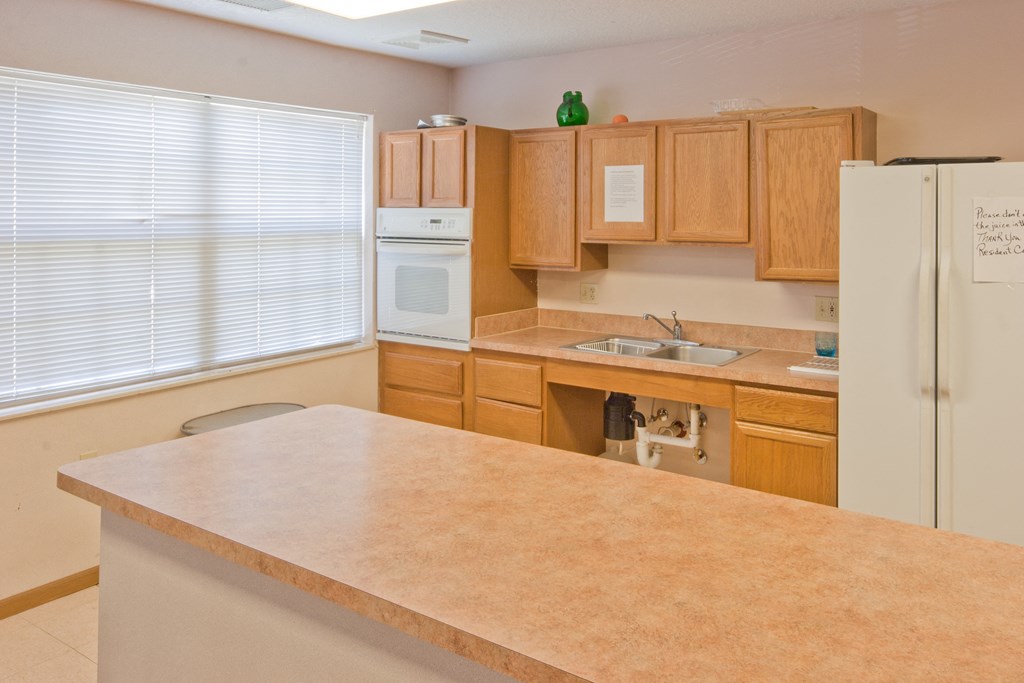 a kitchen with wooden cabinets and a counter top and a refrigerator