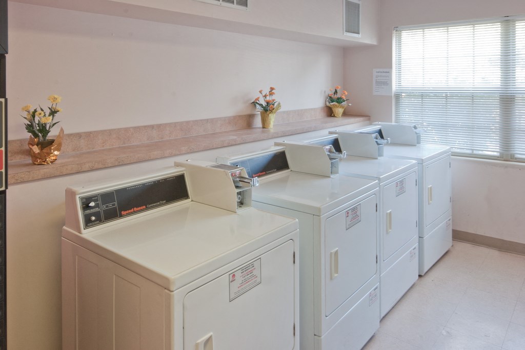 the laundry room has four washes and dryers in it