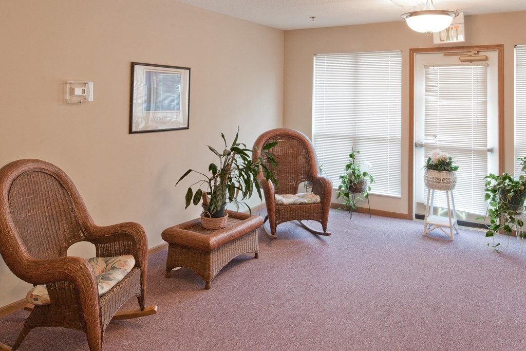 a living room with two chairs and a table and a window