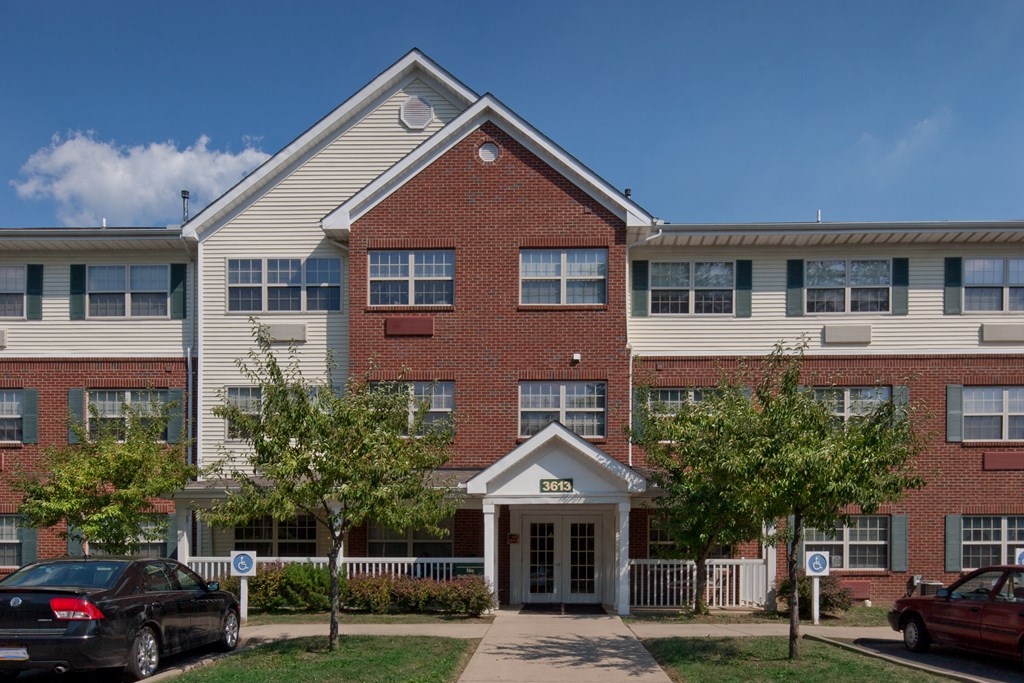 a red brick apartment building with white siding and a white front door