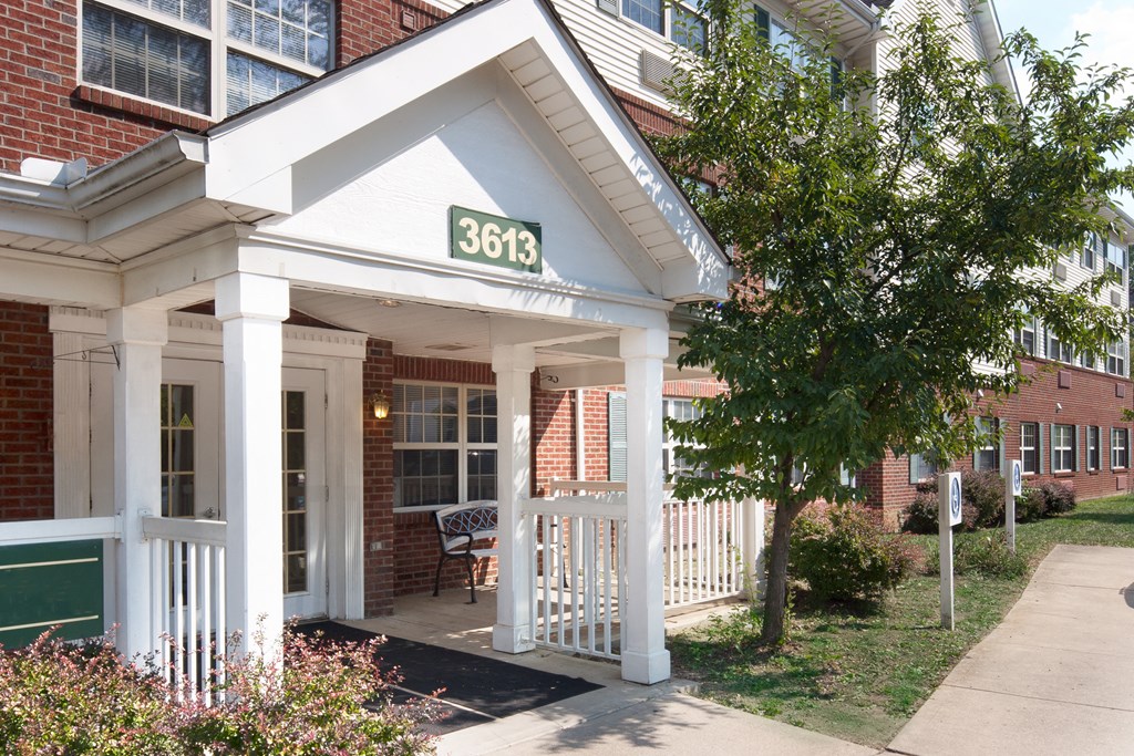 the front porch of a building with a sign on it