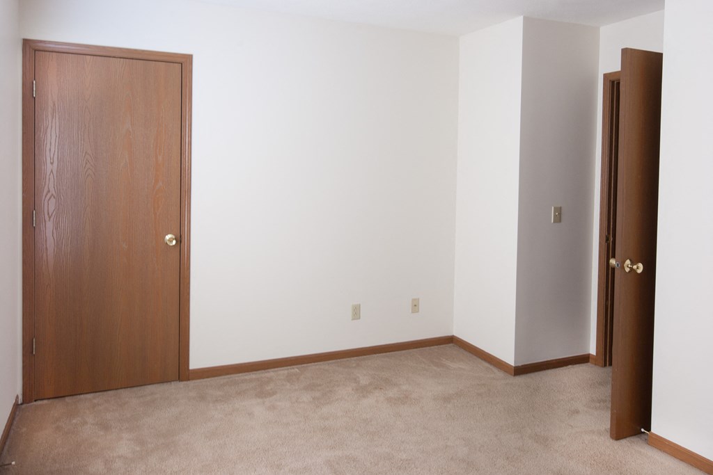 an empty room with a closet and a door