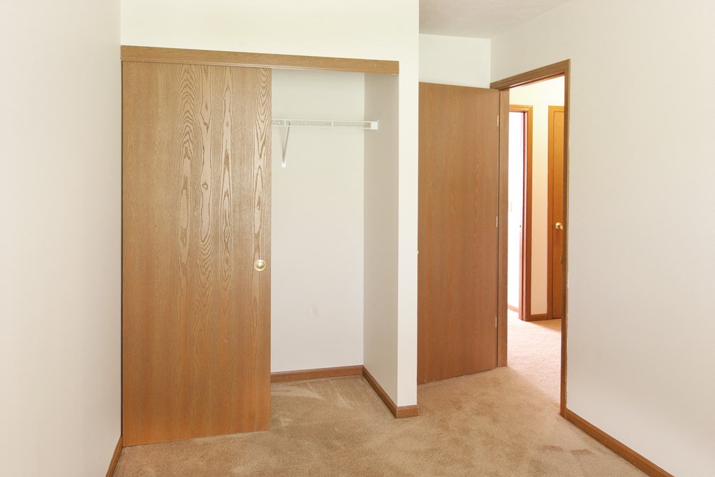 a bedroom with a closet and a door to a bathroom