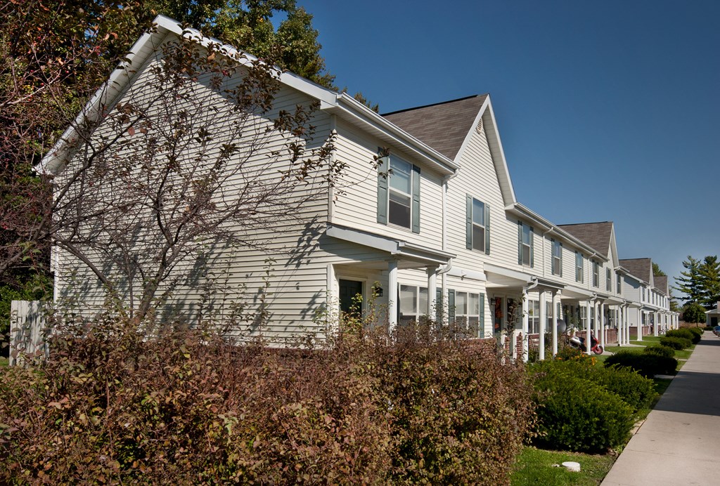a white house with a sidewalk in front of it