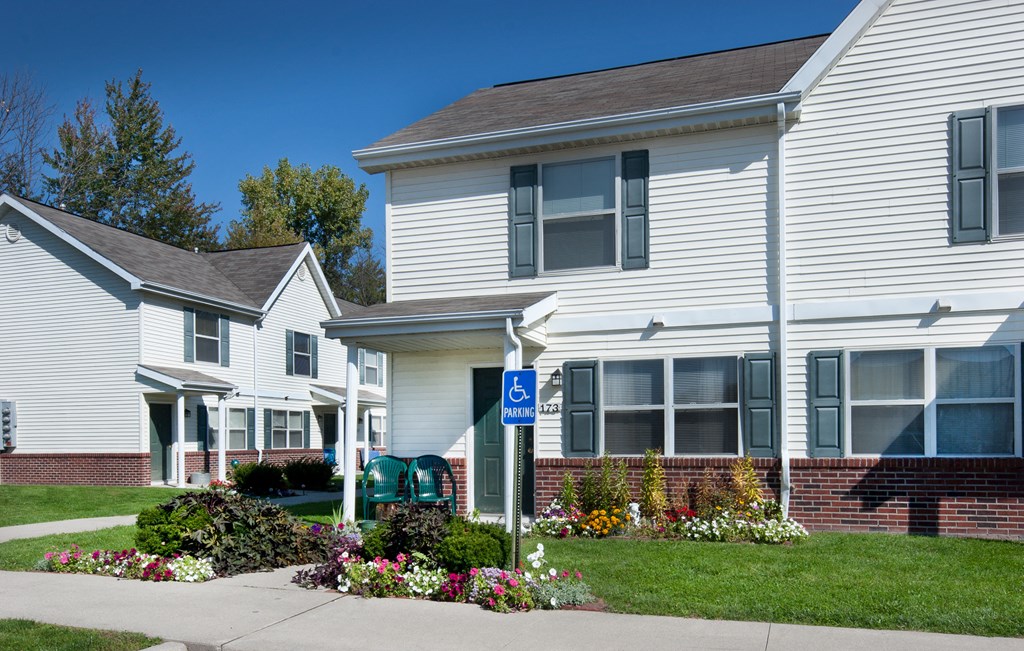 a white house with a handicap sign in front of it