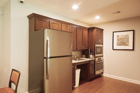 a small kitchen with a stainless steel refrigerator and a sink