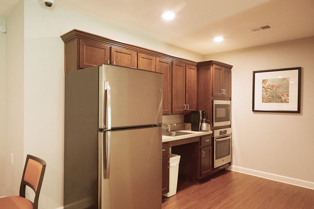 a small kitchen with a stainless steel refrigerator and a sink