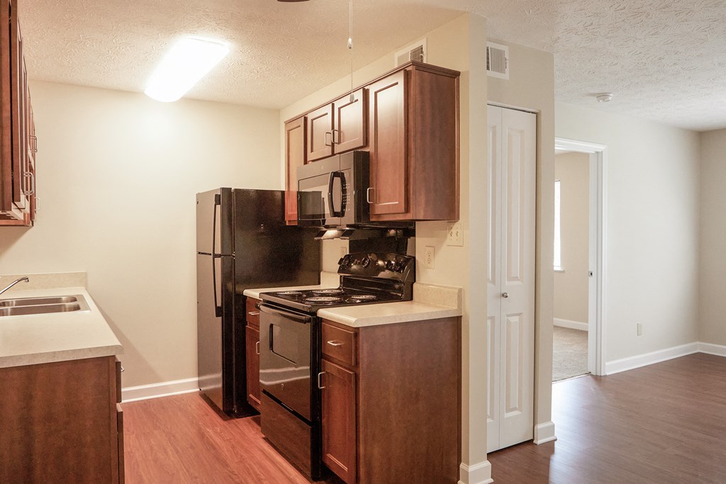 an empty kitchen with a stove refrigerator and a sink
