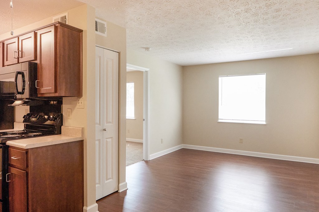 an empty kitchen and living room with wood flooring and