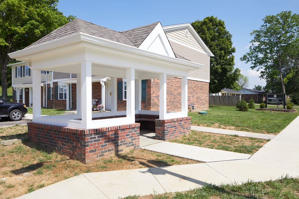 a small brick house with a porch and a sidewalk