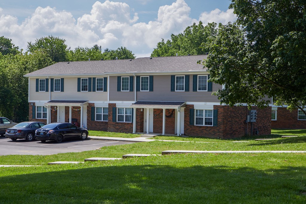 a large apartment building with cars parked in front of it