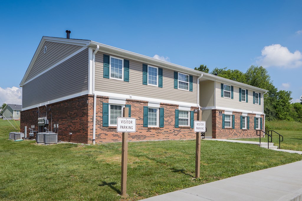 an apartment building with two signs in front of it