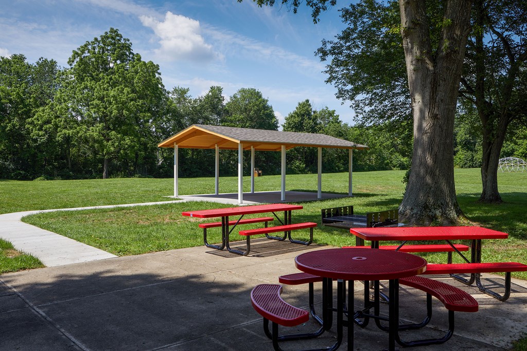 a picnic area with benches and tables in a park