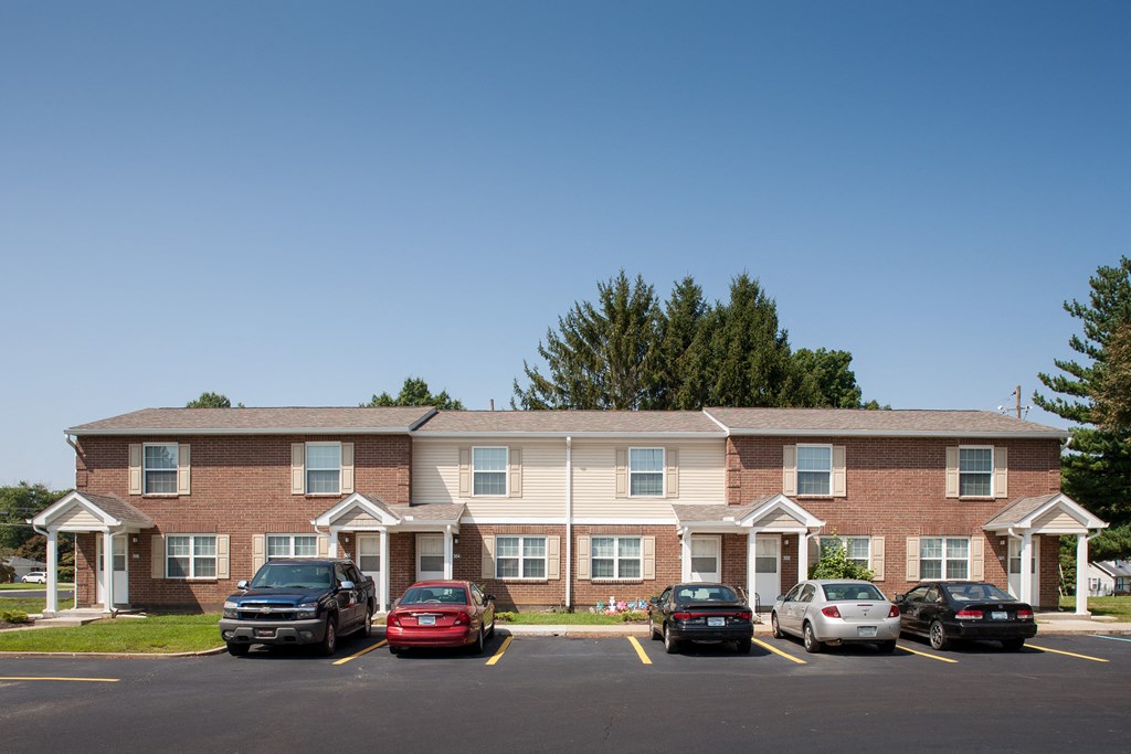 a large apartment building with cars parked in a parking lot