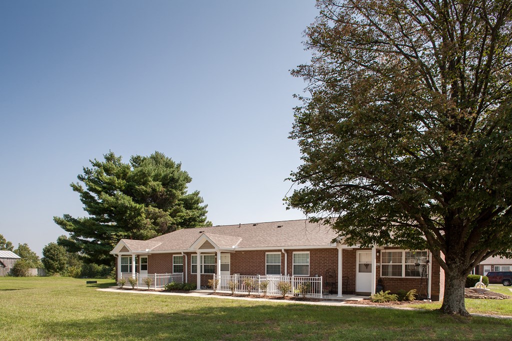 a house with a yard and a tree in front of it