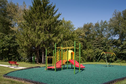 a playground with a red and yellow swing set